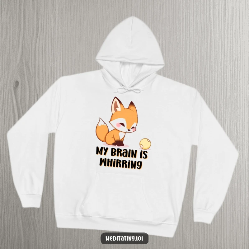 Funny hoodie featuring a curious fox contemplating a tiny bouncing ball, radiating an air of playful contemplation and warmth.