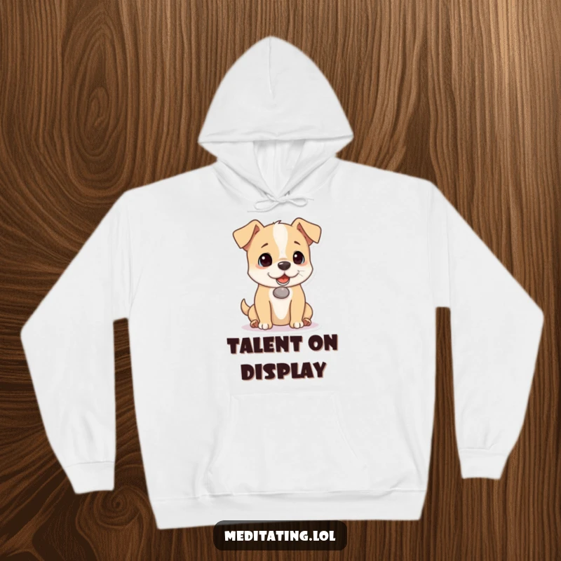 Funny dog hoodie with a playful puppy concentrating intensely on balancing a small pebble on its nose, providing warmth and humor.